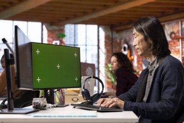 Teknoloji başlangıcında yapay zeka teknolojisiyle çalışan yeşil ekran bilgisayar kullanan kıdemli programcı. Teknoloji başlangıcında yapay zeka sistemleri geliştiren deneyimli işçiler tarafından kullanılan model bilgisayar monitörü