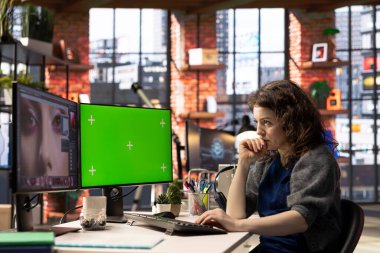 Uzman sanatçı kadın, yaratıcı bir ofiste bilgisayarın yanında dijital fotoğrafları düzenliyor. Kurgu yazılımıyla donatılmış çalışma alanı. Endüstrideki sanatsal çalışmaları geliştirmek.