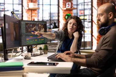 Yapay zeka sohbet robotu ve montaj yapıcı yazılımla çalışan video düzenleme ekibi, arka plan videosu düzenleme ve çift monitörlerde klipleri karıştırma. Profesyonel erkek ve kadın yaratıcı süreç içindeler..