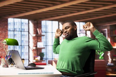 Ofiste uzun süre masa başında oturduktan sonra gerinen biri. Oturma odasında serbest çalışan biri yanlış duruşla oluşan sırt ağrısını hafifletmek için kas egzersizi yapıyor.