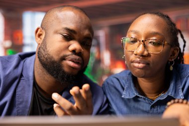 Afrika kökenli Amerikalı çift evlerinde uzaktan çalışıyor, iş stratejileri planlıyor ve proje geliştirmeyi tartışırken aynı zamanda bir dizüstü bilgisayarla ilerlemeyi takip ediyor ve başarıyı garantiliyor..