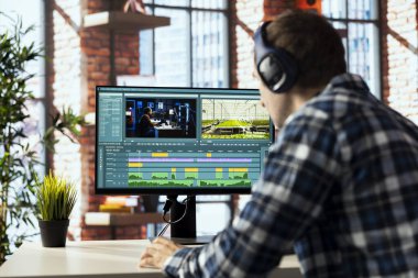 Uzaktan çalışan video kameraman, özel yazılım uygulamaları kullanarak video montajı yapıyor. Video düzenleyici ev ofisindeki film projesinin görüntülerini kesmek için PC üzerindeki düzenleme araçlarını kullanıyor