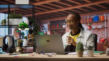 Evde e-posta yazmak için defter kullanırken tele-işçi kahve içiyor. Uzaktan kumandalı çalışan sıcak içecekten zevk alıyor ve dizüstü bilgisayar kullanıyor, son proje evraklarını teslim etmek için belgeler hazırlıyor, kamera A