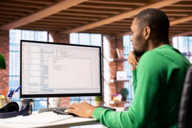 Programcı PC 'ye kod yazar, komutları girer, betiği çalıştırır. Afrika kökenli Amerikalı bilişim uzmanı apartman dairesinde hata düzeltme, yeni özellikler uygulama
