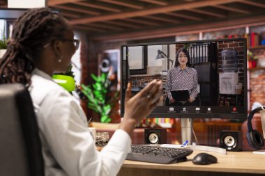 Kadın, insan kaynakları temsilcisiyle görüntülü görüşme yapıyor, el sallıyor, şirket pozisyonu için başvuruyor. Aday evde HR işvereni ile telekonferans toplantısı yapıyor, onu selamlıyor.