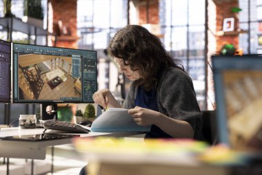 Grafik sanatçısı, bilgisayarında mimari yazılım kullanarak bir iç mekanın üç boyutlu detaylı bir canlandırmasını yapıyor. Program, sanal bir düzen için mobilya ve diğer tasarım elemanlarını yapılandırmaya izin verir.