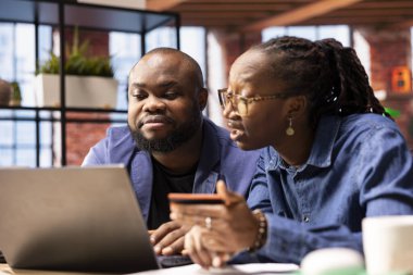 Bilgisayarda aile tatili için rezervasyon yaptıran insanlar, ödeme onaylamak ve otel odasıyla bir seyahat rezervasyonu yaptırmak için banka kartlarını girenler. Seyahat planları düzenleyen kendinden emin insanlar.