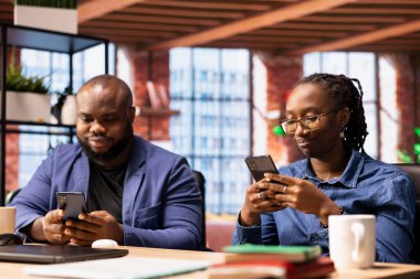 Afrikalı Amerikalı çift, günlük serbest çalışmaya başlamadan önce internet üzerinden yazışmalarını kontrol edip e-posta gönderiyorlar. Birlikte yaşayan ve uzaktan çalışan genç yetişkinler..