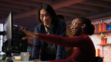 Yapay zeka girişiminde neşeli bir yönetici işçi kodlama uygulamalarıyla gülüyor. Mutlu takım lideri çalışanıyla şakalaşıyor rahat çalışma alanında kod testi yapıyor, kamera B