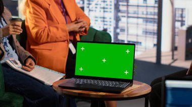 Yeşil ekranın yanında yeni stratejileri tartışan çok ırklı kadınlar, performans ölçümlerini ve değerlendirme için diğer verileri gözden geçiriyorlar. Erkeklerin hakim olduğu bir ortamda çalışan bir grup lider. Kamera A.