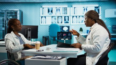 Afrika kökenli Amerikalı doktor ve hasta detaylı bir sağlık kontrolüne tabi tutuluyor, profesyonel bakım ve sağlık önlemlerini vurguluyor. Kronik bozukluk var. Kamera B.