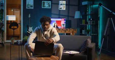 Teknoloji meraklısı kullanıcı yeni bir yazılımı test etmek, yeni dijital araçları kullanmak ve çevrimiçi işleri yönetmek için kişisel dizüstü bilgisayarı üzerinde çalışıyor. Konforlu evinden birbirine bağlı ve üretken bir yaşam tarzı. Kamera B.