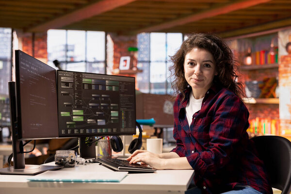 Портрет улыбающейся женщины в офисе стартапа при проектировании, кодировании и отладке приложений на разных языках программного обеспечения. Веселый ИТ-специалист для тестирования кода и обеспечения качества