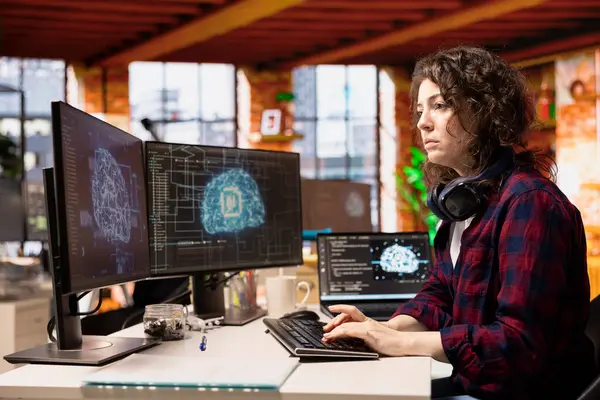 Yapay zekaya sahip bir kadın farklı yazılım dillerindeki uygulamaları tasarlamaya, kodlamaya ve hata ayıklamaya odaklandı. Bilişim uzmanı kod testi ve kalite güvencesi yapıyor
