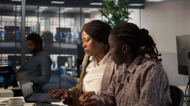 Genel müdür, proje geliştirme ve kurumsal hedefler üzerine bir oturuma öncülük eden bir çalışanla birlikte mali tahminleri gözden geçiriyor. İş amaçlarına ulaşmak için işbirliği yapmak. Kamera B.