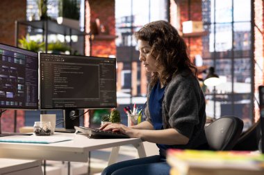 Afrikalı Amerikalı yazılım mühendisi çift monitörler ve bir geliştirme projesi için daktilo kodu üzerinde çalışıyor. Teknik geliştirici çoklu görev, hata ayıklama ve kodlama için gelişmiş dijital araçlar kullanma.