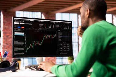 Gündüz işlemcisi bilgisayar kullanıyor, iyi performans gösterebilecek hisse senedi alıyor ve değeri düşebilecek hisse senedi satıyor. Eski tüccar PC masasında hisse senedi portföy sayfalarına göz atıyor