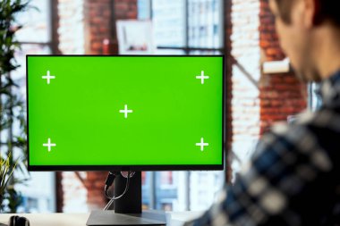 Çalışma alanındaki adam izole ekran PC 'sinde online eğitim oturumuna katılıyor, rota modüllerinde geziniyor. Ofisteki çalışanlar bilgisayar monitöründeki eğitici şirket videolarını izliyorlar.