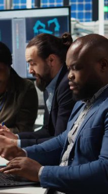 Fabrika ofisindeki dikey video mühendisleri artan enerji üretimi için dizüstü bilgisayar kullanarak performans verileri topluyor. Fotovoltaik uzmanları yenilikçi güneş pili prototipleri tasarladılar