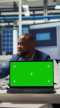 Dikey video fabrikası mühendisleri kroma anahtar dizüstü bilgisayar kullanarak üretim planlarını rafine ediyorlar. Uzmanlar, izole ekran defteri kullanarak prototipler için sanayi tesisi yapılandırmalarını özetliyor