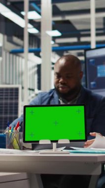 Dikey video fabrikası mühendisi montaj çizgileri şemalarını incelerken tökezliyor, yeşil ekran tableti kullanarak üretim planlarını inceliyor. Uzmanlar endüstriyel fabrika yapılandırmalarını modelleme kullanarak özetliyorlar