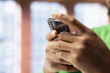 Evdeki adam e-postaları yakalamak ve cevap vermek için akıllı telefonu kullanıyor. Oturma odasındaki kişi gelen kutusundaki mesajları okuyor, cep telefonu dokunmatik ekranında yazıyor, görüntüyü kapatıyor.