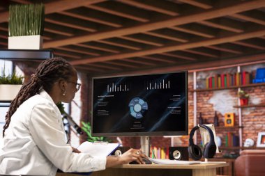 Ofiste telgraf işçisi bilgisayar ekranında iş sunumunu izliyor, istatistik tablolarına bakıyor. Apartmandaki Afrikalı Amerikalı uzaktan çalışan bilgisayardaki sunum grafiklerine bakıyor.