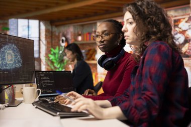 Yapay zeka programcılarından oluşan bir ekip, işçi tasarımını, kodlamasını ve hata ayıklamasını denetlemeye başladı. Kod testi ve kalite güvencesi yapan takım arkadaşları