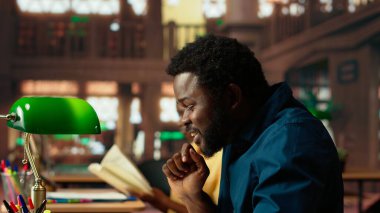 Stresli erkek öğrenci, yaklaşan sınav notlarını ezberlemenin akademik mücadelesi yüzünden hayal kırıklığına uğramış hissediyor. Öğrenci üzgün ve notları için endişeleniyor. Kamera B.