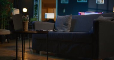 Modern ev bitkileri ve neon ışıkları olan çağdaş bir daire akıllı televizyonlu ve rahat bir oturma odası yaratıyor. Moda mobilyalı boş stüdyo dairesi.