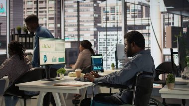 Tekerlekli sandalyedeki Afrikalı Amerikalı erkek işçi ofiste günlük işleri çözmeye çalışıyor, örgütsel verileri inceliyor ve bir tahmin planı üzerinde çalışıyor. Hasarlı bir adam analizi garanti altına alır. Kamera B.