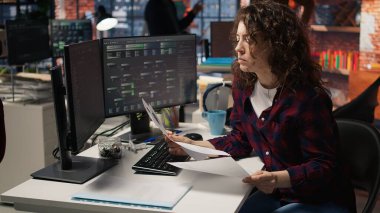 Teknik girişim sektörü İK çalışanı CV 'lere bakıyor, potansiyel iş başvuruları için yetenek ediniyor. Yazılım geliştirme adaylarının özgeçmişlerini okuyan kadın boş pozisyon, kamera A