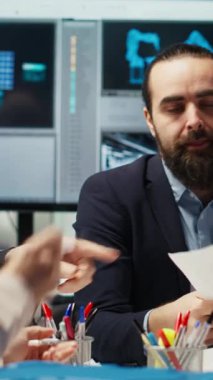 Dikey video sektörü yöneticileri, otomasyon teknolojisinin güneş paneli üretim süreçlerine entegrasyonunu tartışmak üzere yatırımcılarla bir araya gelerek evrak ve şemalara, kamera B 'ye bakıyorlar.