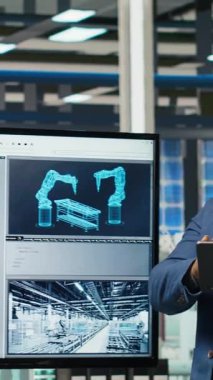 Yatırımcıların önünde sunum yapan dikey video fabrikası yöneticileri üretim hatlarının planlarını gösteriyor. Endüstriyel fabrika yapılandırmalarını hissedarlara sunan yönetim, kamera B