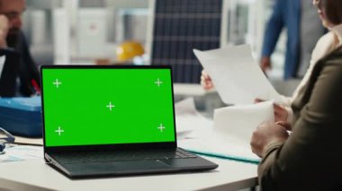 Endüstriyel fabrika müdürü yeşil ekranda yazı yazıyor, iş toplantısından önce evrak hazırlıyor. Fabrika yöneticisi yatırımcılar için sunum üzerinde çalışıyor. Krom anahtar defteri kullanarak, üretimi otomatikleştirerek.