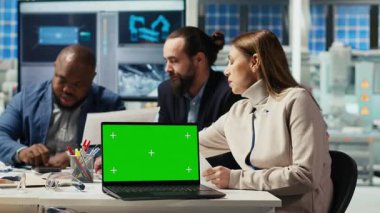 Fabrika mühendisleri verileri kullanarak enerji üretimini arttırmak için yeşil ekran dizüstü bilgisayar kullanıyorlar. Fotovoltaik bitki uzmanları güneş pili prototiplerini krom anahtar defter, kamera B 'de tasarlıyorlar.