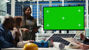 Araştırmacılar izole ekran monitörüne bakarak enerji üretimini optimize etmek için güneş pili prototiplerini analiz ediyorlar. Güneş panelleri bitki uzmanları kroma anahtar ekran kullanarak yenilikçi üretim teknolojisi geliştirirler