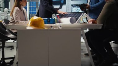 Fabrika yöneticileri yatırımcılara sürdürülebilir üretim çözümleri sunuyorlar. Endüstriyel fabrika yöneticileri, hissedarlara yenilikçi güneş paneli otomasyon teknolojileri sunuyorlar, kamera A