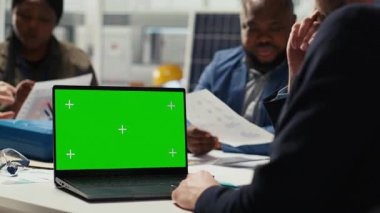 Hissedarlar, anlaşmanın uygulanabilirliğini değerlendirmek amacıyla geri dönüşleri tasarlamak için model dizüstü bilgisayar kullanıyorlar. İlgilenen yatırımcılar için finansal analiz yapan, yeşil ekran defteri kullanan muhasebeci