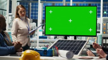 Fotovoltaik fabrikasındaki iş adamları görüntüdeki verilere bakarlar. Güneş panelleri fabrika yönetim ekibi ve yatırımcı anlaşma şartlarını yeşil ekran monitöründe gösteriyorlar, kamera B