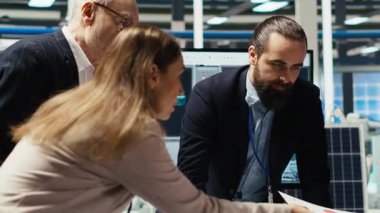 Endüstriyel fabrika yöneticileri ve yatırımcılar evrak belgelerindeki teknik üretim verilerini analiz ederler. Fabrika yönetimi otomasyon geliştirmelerini kontrol ediyor. Belgeler, kamera B