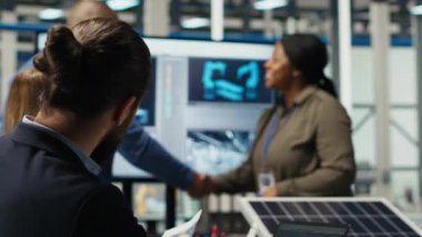 Yatırımcılar el sıkışıyor, güneş paneli üretimi için otomasyon stratejileri hakkında konuşmak için toplanıyorlar. Hissedarlar fotovoltaik fabrikasında el sıkışma yapıyor, kamera B