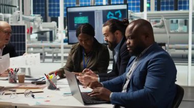 Fabrika ofisindeki mühendisler artan enerji üretimi için dizüstü bilgisayar kullanarak performans verileri topluyorlar. Fotovoltaik uzmanları yenilikçi güneş pili prototipleri tasarlıyorlar, kamera A