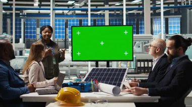 Güneş panelleri fabrika yöneticisi, imalat stratejilerini yatırımcılara sunmak için izole ekran monitörü kullanır. Fotovoltaik fabrikası yöneticisi, hissedarlara verileri göstermek için maket ekran kullanır, kamera A