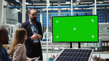 Fotovoltaik bitki araştırmacıları toplantı yapıyor, yeşil ekran monitörüne bakıyor, enerji üretimini değerlendiriyor. Uzmanlar, fabrika ekipman enerji üretimini optimize ederek, model ekran, kamera A 'ya bakıyorlar.