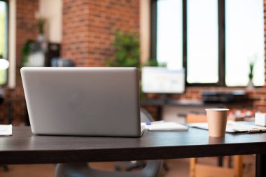 Başlangıç ofisi toplantılar ve araştırmalar için düzgün bir şekilde hazırlandı, dizüstü bilgisayar ve kağıtlar gibi gerekli iş eşyalarıyla dolu boş bir masaya sahip olmak. Dijital cihazlı masa, kahve fincanı ve belgeler, yoğun bir gün için hazır..