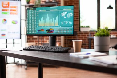 Boş bir iş yerinde yapılacak toplantıya hazırlık olarak pazarlama stratejisi araştırmasını gösteren bilgisayar ekranı. Kimsesiz tuğla duvar odası şirket analizlerini gösteren dijital cihazlarla düzenlenir.