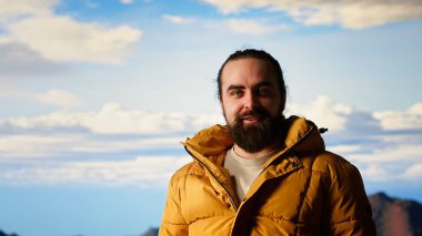 Yürüyüşçü dağın tepesine ulaşır ve başarılı bir tırmanıştan sonra zafer pozu verir. Bu da maceraya olan güveni yansıtır. Gezgin korkuları yenmenin kişisel başarısının tadını çıkarıyor. Kamera B.