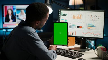 Bir program için fon araştıran ve tablet tutan genç bir adam, bir yazılımda finans ve muhasebe yönetimi okuyor. Başlangıç için uzaktan kumandalı iş yapan bir erkek uzman. Kamera B.