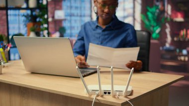 Evde zayıf internet bağlantısıyla boğuşan, LAN kablosunu çıkaran ve sinyali geri getirmek için Wi-Fi ayarlarını ayarlayan genç bir kadın. Teknik sorunları olan serbest çalışan bir kadın. Kamera A.